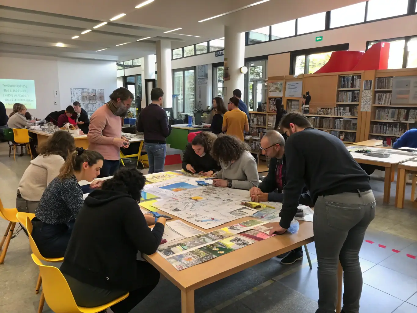 A photograph of a workshop session in progress, showing attendees actively participating in a hands-on activity, with facilitators guiding the session.